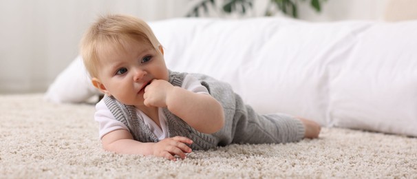 Photo of Cute little baby near bed at home