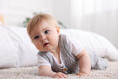 Photo of Cute little baby near bed at home