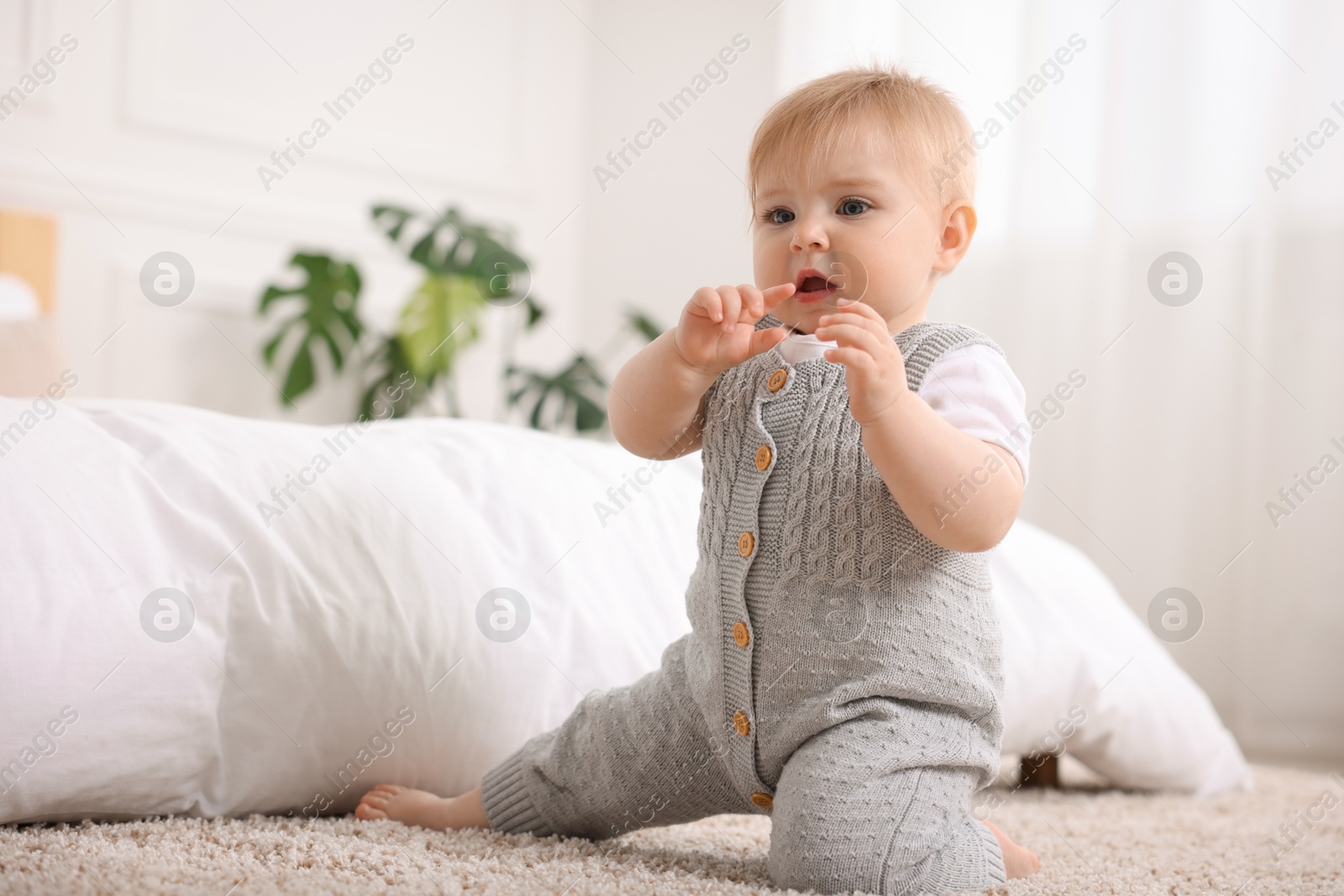 Cute little baby near bed at home Photo of Cute little baby near bed at home