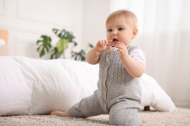 Photo of Cute little baby near bed at home