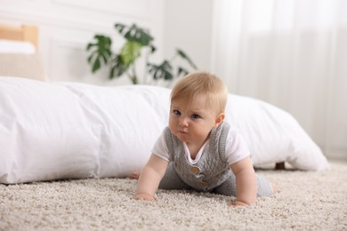 Photo of Cute little baby near bed at home