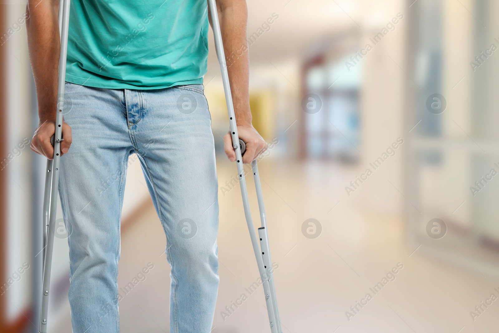 Man with axillary crutches in hospital, closeup. Space for text Image of Man with axillary crutches in hospital, closeup. Space for text