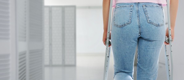 Image of Woman with axillary crutches in hospital, closeup. Banner design