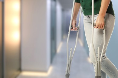 Image of Woman with axillary crutches in hospital, closeup. Space for text