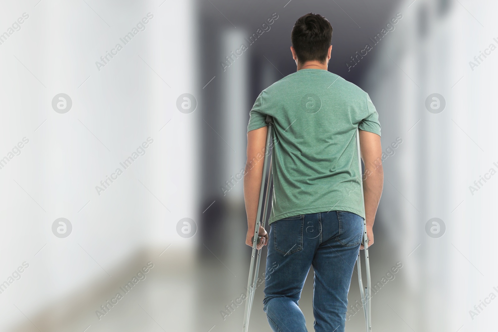 Man with axillary crutches in hospital, back view Image of Man with axillary crutches in hospital, back view