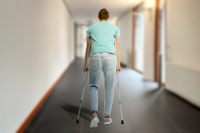 Image of Man with axillary crutches in hospital, back view