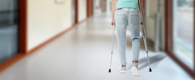 Image of Man with axillary crutches in hospital, closeup. Banner design