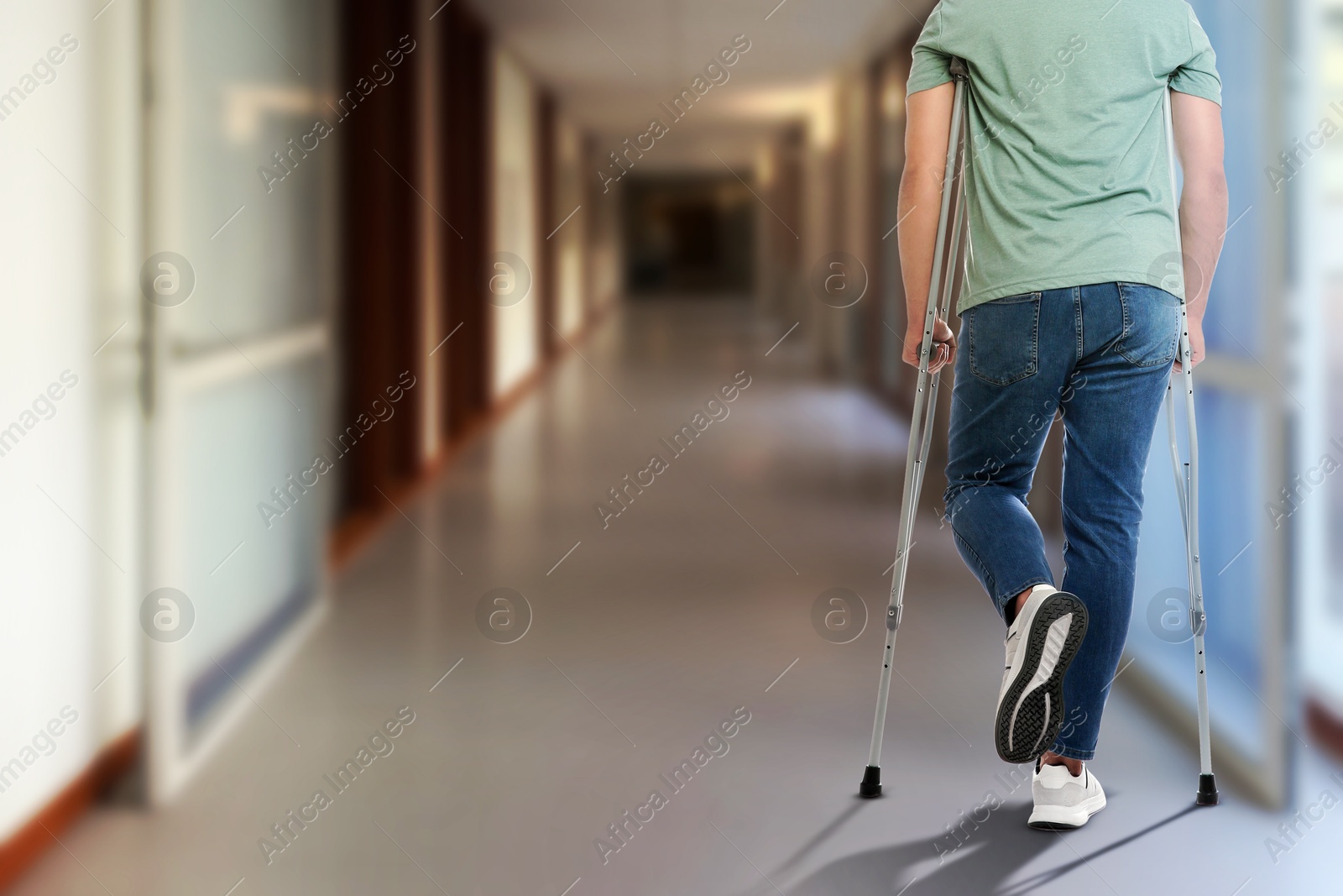 Man with axillary crutches in hospital, closeup. Space for text Image of Man with axillary crutches in hospital, closeup. Space for text