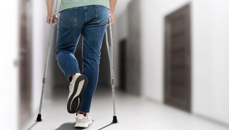 Image of Man with axillary crutches in hospital, closeup. Banner design
