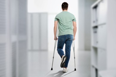 Image of Man with axillary crutches in hospital, back view