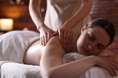 Photo of Woman receiving back massage with oil in spa salon