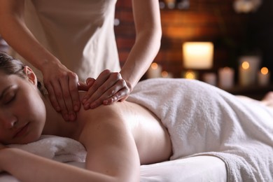 Photo of Woman receiving back massage with oil in spa salon, closeup