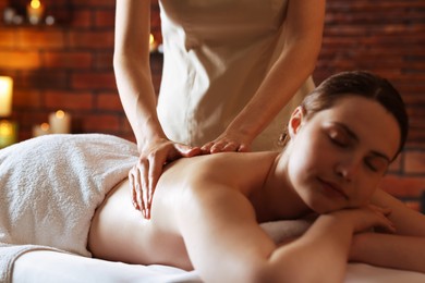 Photo of Woman receiving back massage with oil in spa salon