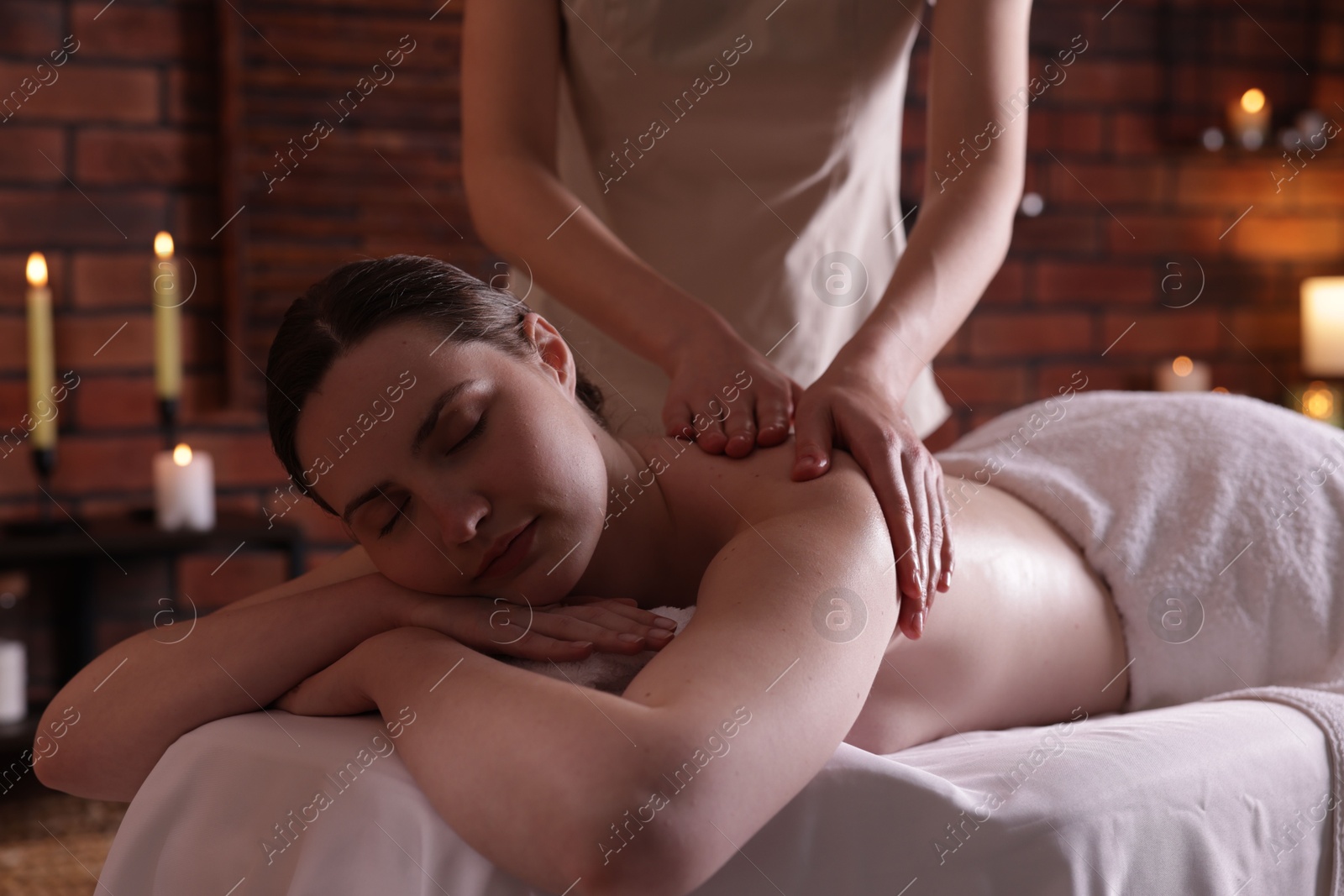 Woman receiving back massage with oil in spa salon Photo of Woman receiving back massage with oil in spa salon