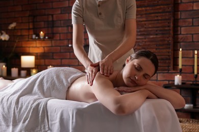Photo of Woman receiving back massage with oil in spa salon