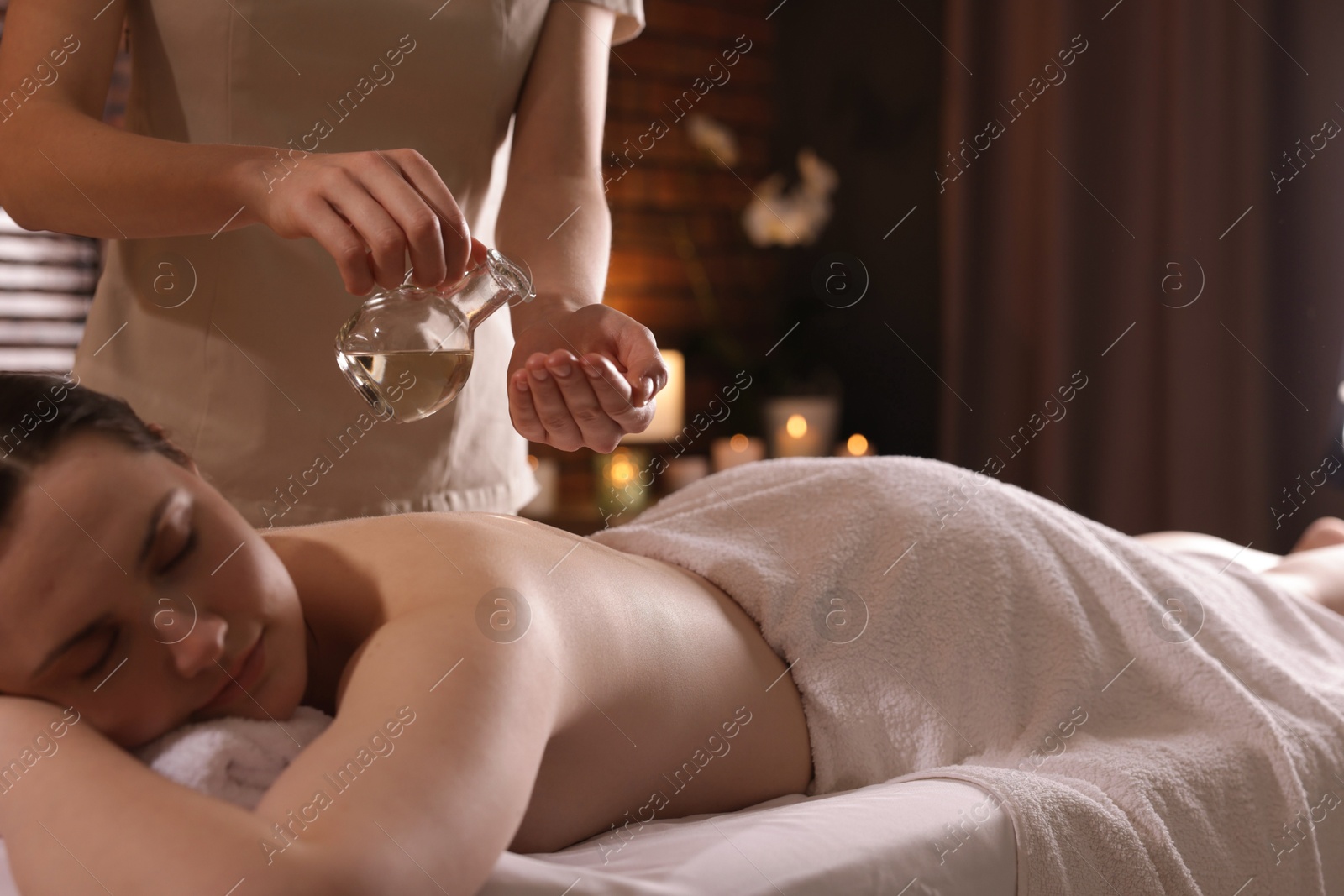 Woman receiving back massage with oil in spa salon Photo of Woman receiving back massage with oil in spa salon