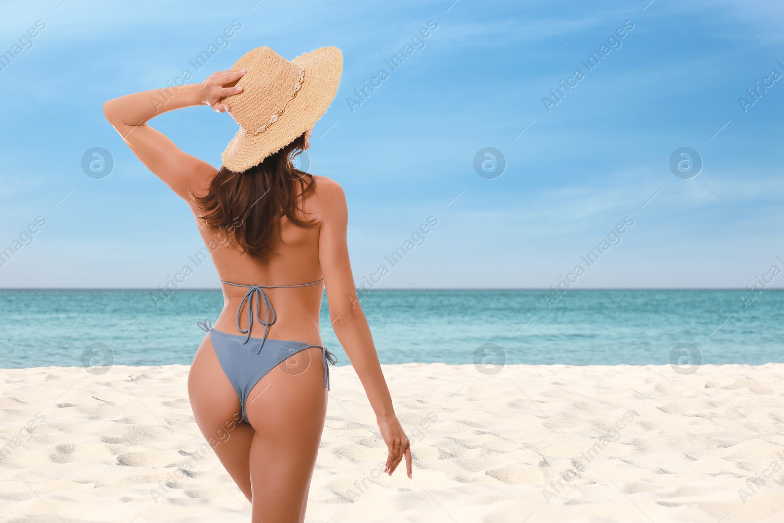 Attractive woman in light blue swimsuit on beautiful beach, back view Image of Attractive woman in light blue swimsuit on beautiful beach, back view