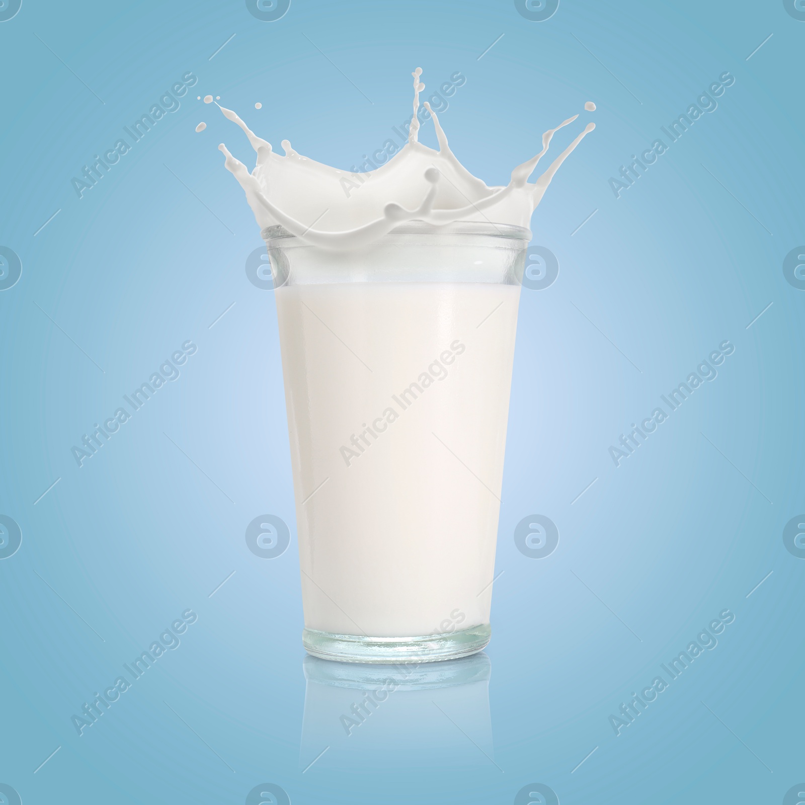 Milk splashing out of glass on light blue background Image of Milk splashing out of glass on light blue background