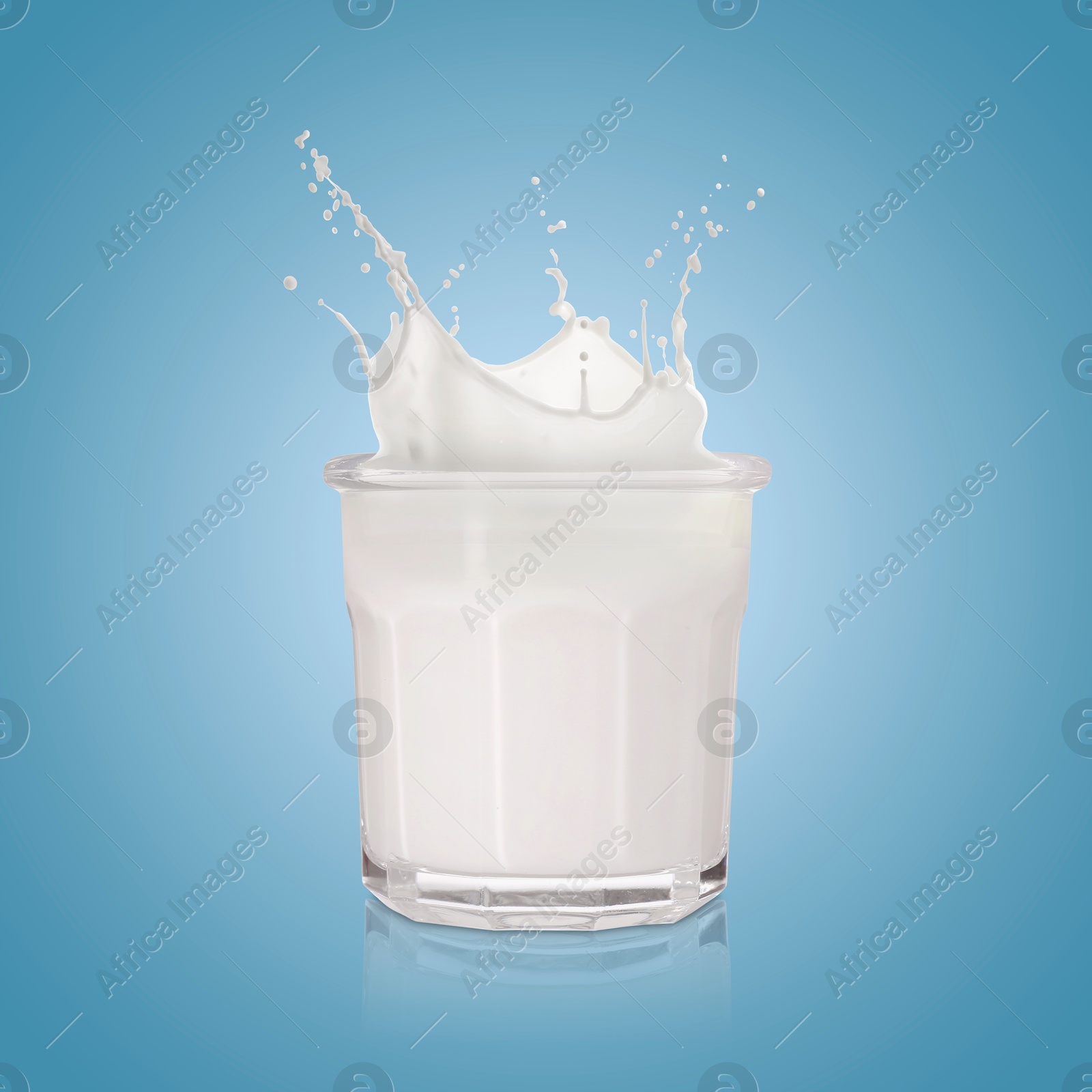 Milk splashing out of glass on light blue background Image of Milk splashing out of glass on light blue background