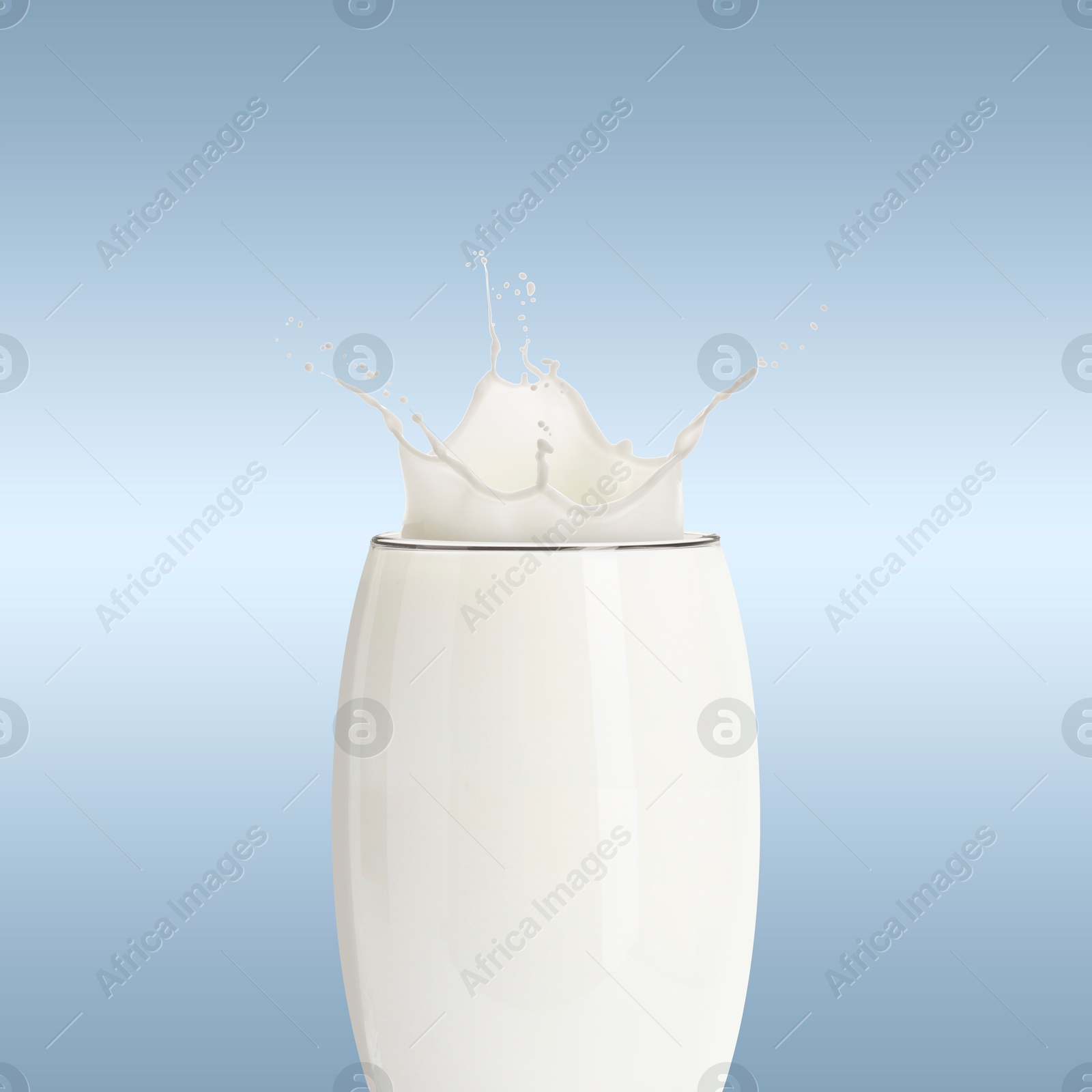 Milk splashing out of glass on light greyish blue background Image of Milk splashing out of glass on light greyish blue background
