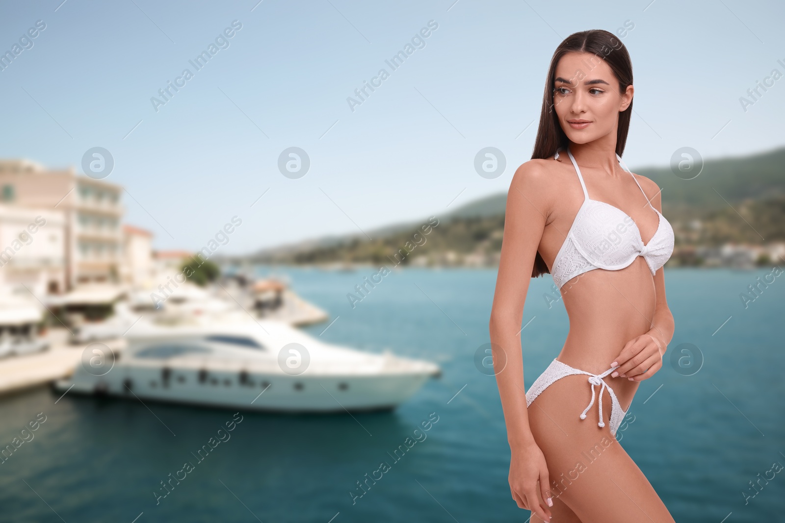 Attractive woman in white swimsuit on pier. Vacation at sea resort Image of Attractive woman in white swimsuit on pier. Vacation at sea resort