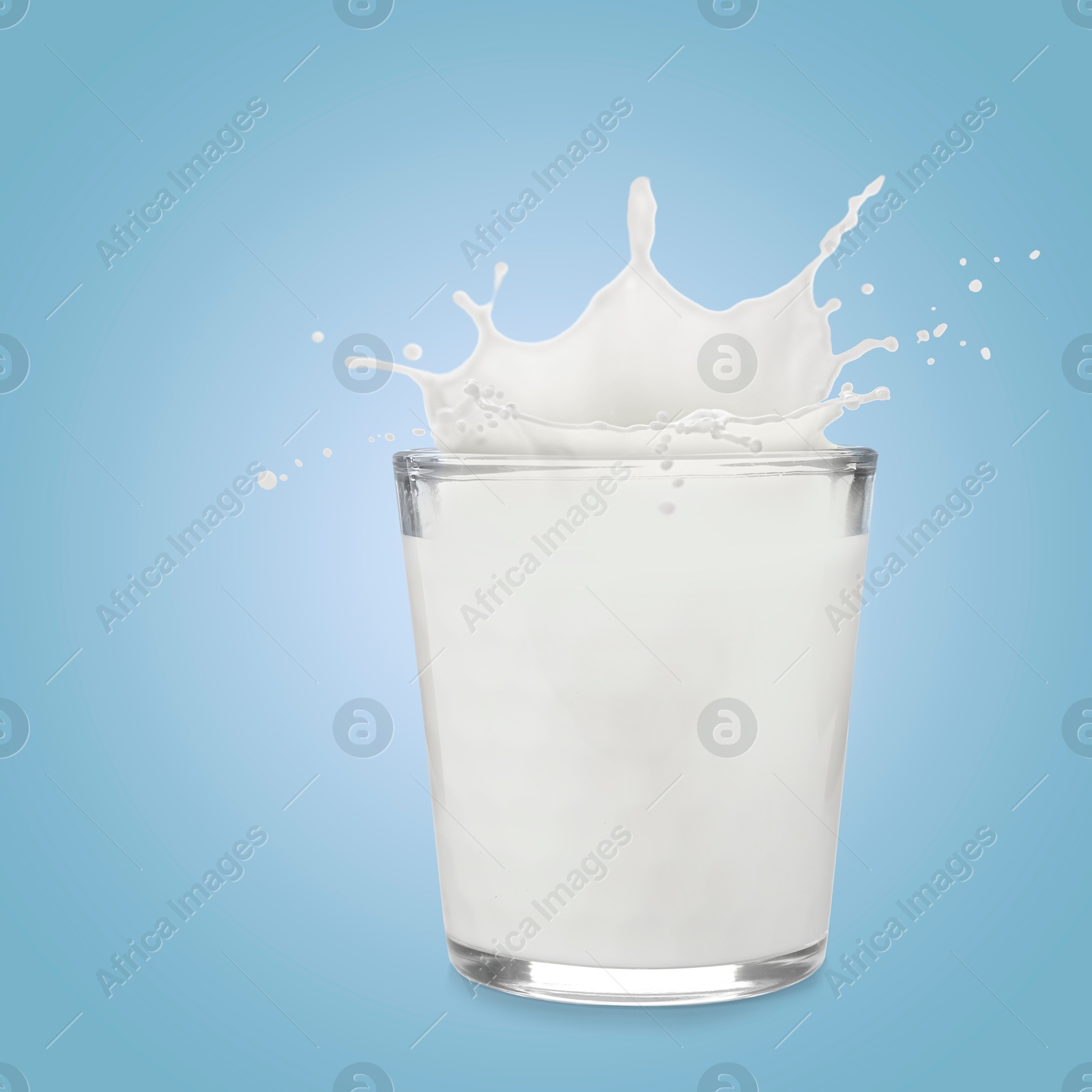 Milk splashing out of glass on light blue background Image of Milk splashing out of glass on light blue background
