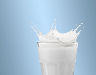 Image of Milk splashing out of glass on light greyish blue background