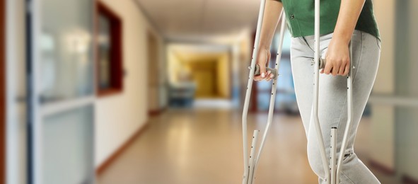 Image of Woman with axillary crutches in hospital, closeup. Banner design