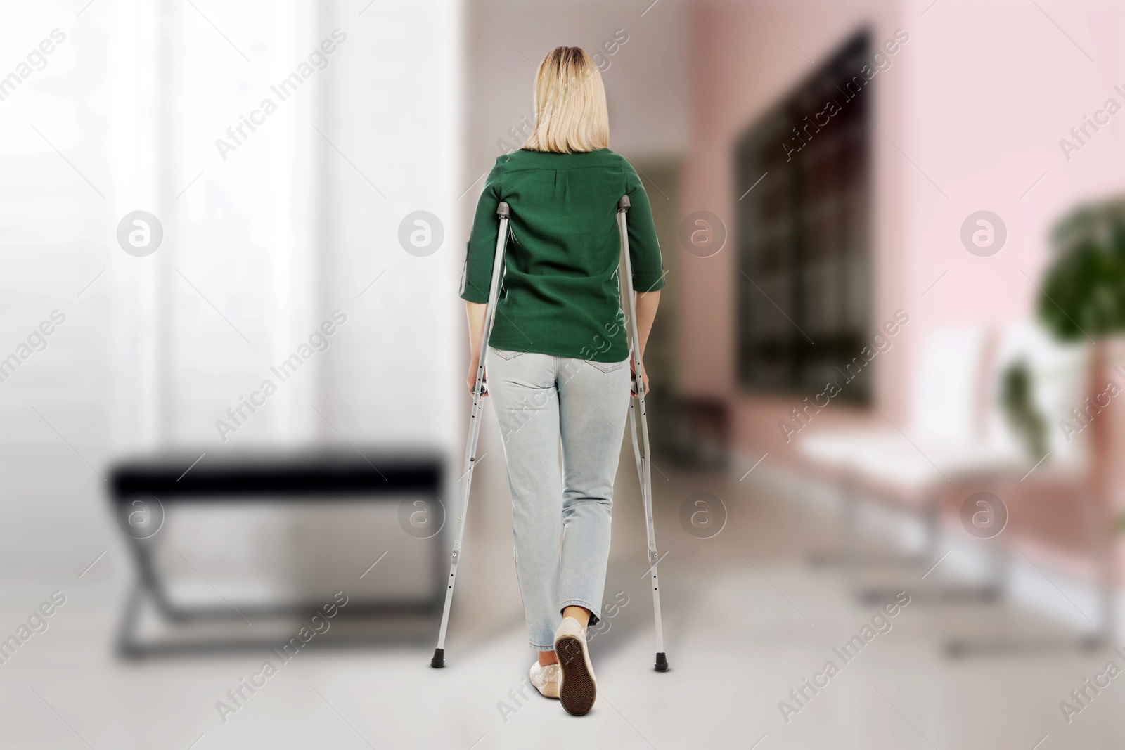 Woman with axillary crutches in hospital, back view Image of Woman with axillary crutches in hospital, back view
