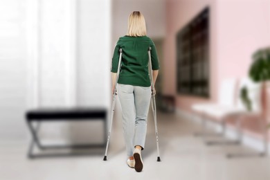 Image of Woman with axillary crutches in hospital, back view