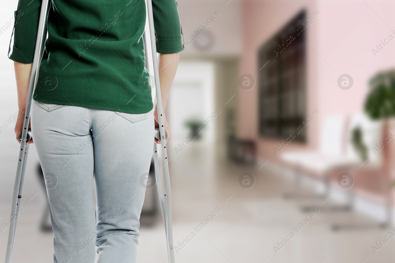 Woman with axillary crutches in hospital, closeup. Space for text Image of Woman with axillary crutches in hospital, closeup. Space for text