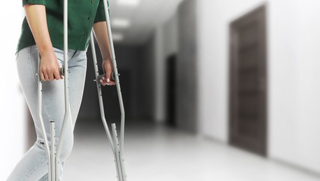 Image of Woman with axillary crutches in hospital, closeup. Banner design