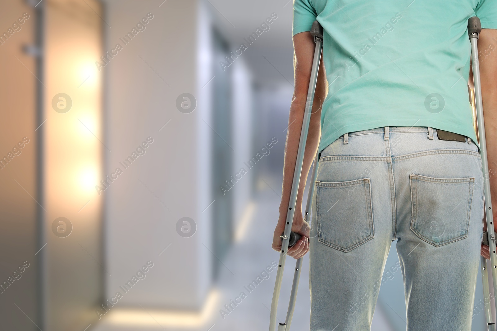 Man with axillary crutches in hospital, closeup. Space for text Image of Man with axillary crutches in hospital, closeup. Space for text