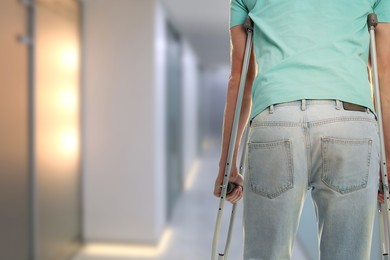 Image of Man with axillary crutches in hospital, closeup. Space for text