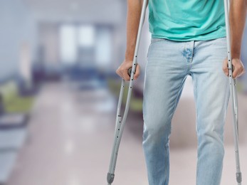 Image of Man with axillary crutches in hospital, closeup. Space for text