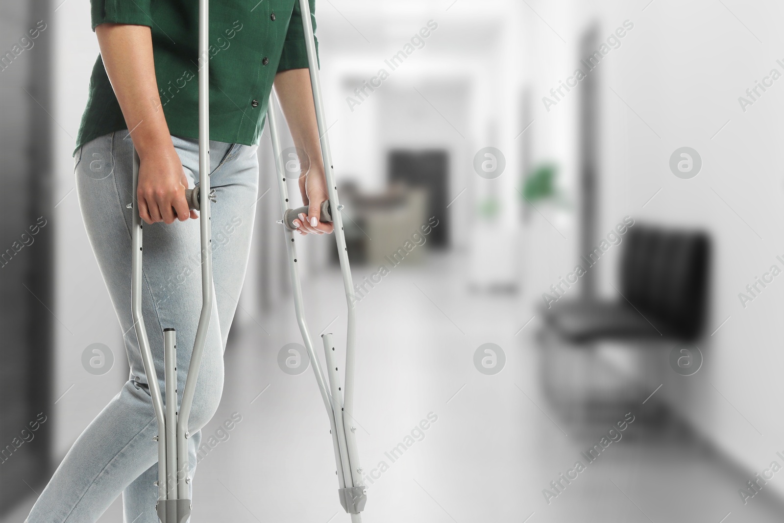 Woman with axillary crutches in hospital, closeup. Space for text Image of Woman with axillary crutches in hospital, closeup. Space for text