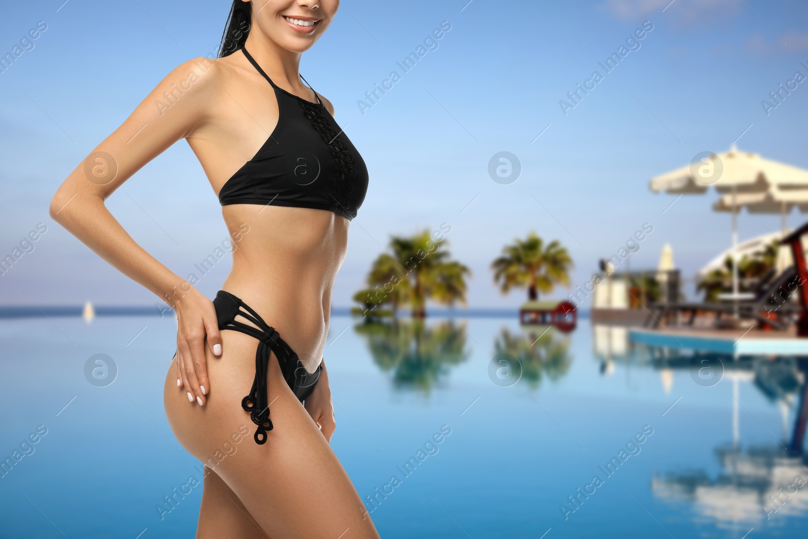Pretty woman in stylish black swimsuit near outdoor swimming pool, closeup. Vacation at sea resort Image of Pretty woman in stylish black swimsuit near outdoor swimming pool, closeup. Vacation at sea resort