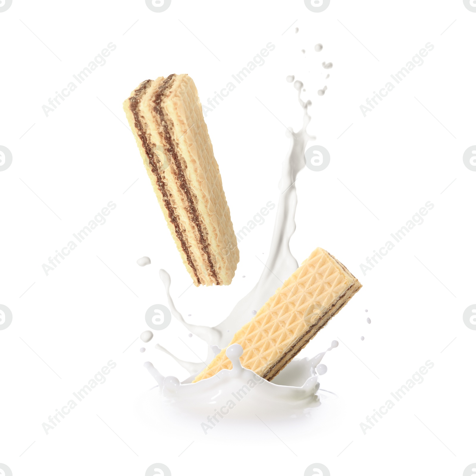 Tasty crispy wafers falling into splashing milk against white background Image of Tasty crispy wafers falling into splashing milk against white background
