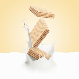 Image of Tasty crispy wafers falling into splashing milk against beige beige background