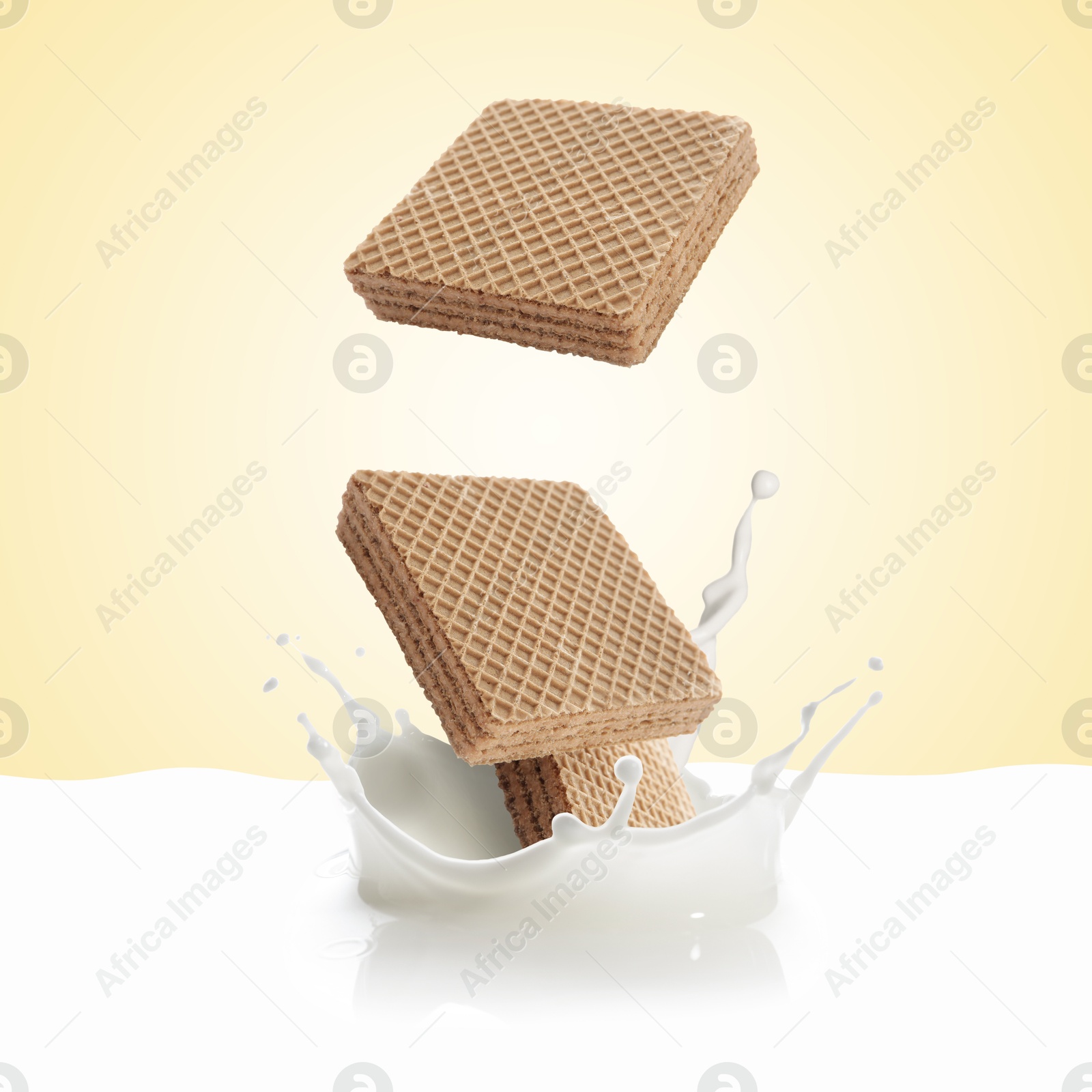 Tasty crispy wafers falling into splashing milk against beige background Image of Tasty crispy wafers falling into splashing milk against beige background