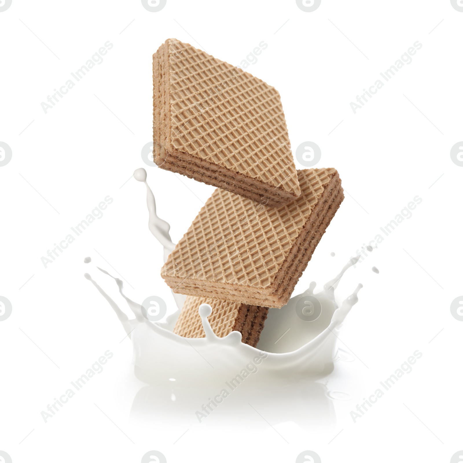 Tasty crispy wafers falling into splashing milk against white background Image of Tasty crispy wafers falling into splashing milk against white background