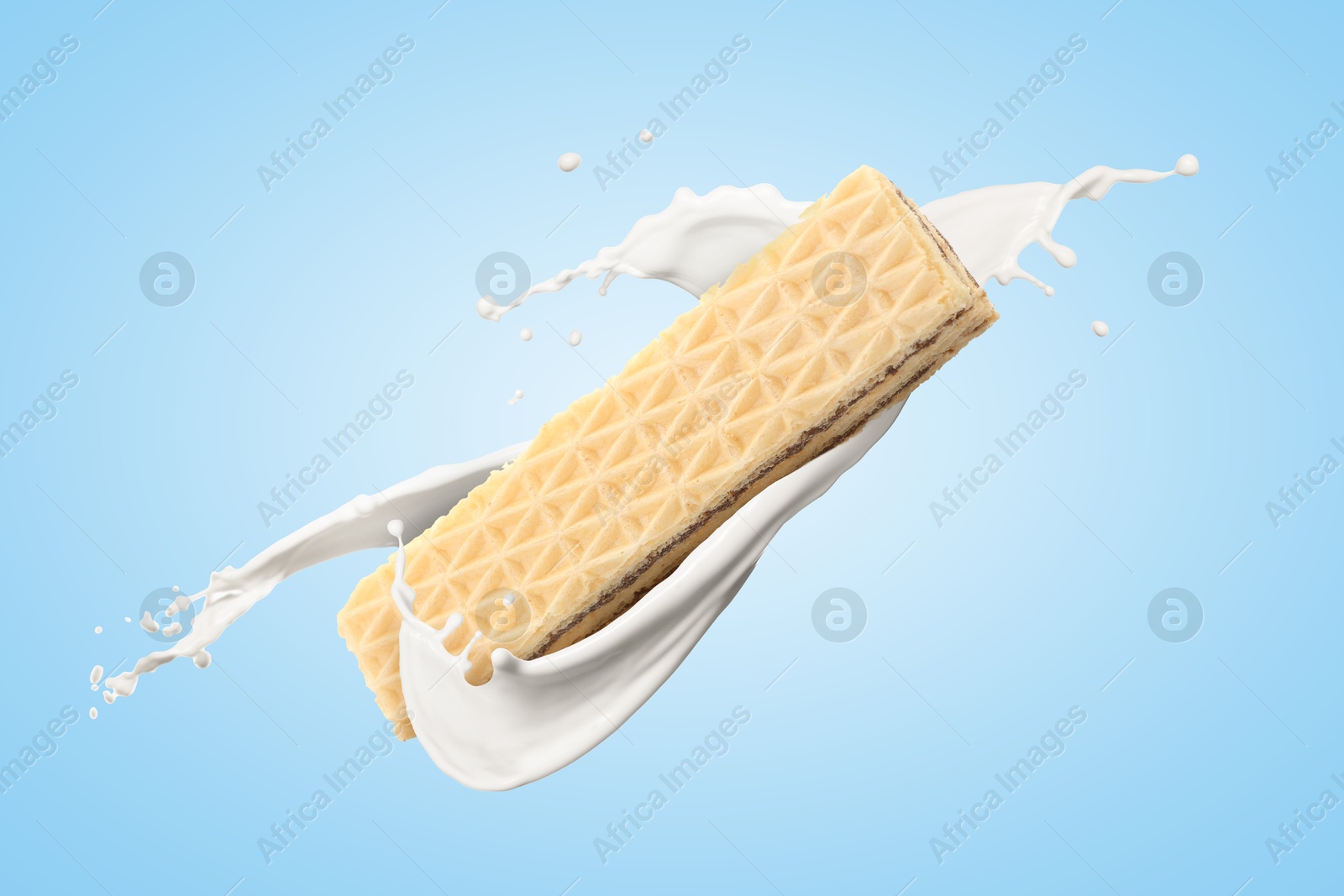 Tasty crispy wafer and splashing milk on light blue background Image of Tasty crispy wafer and splashing milk on light blue background