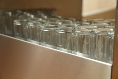 Photo of Many clean glasses on stand in school canteen
