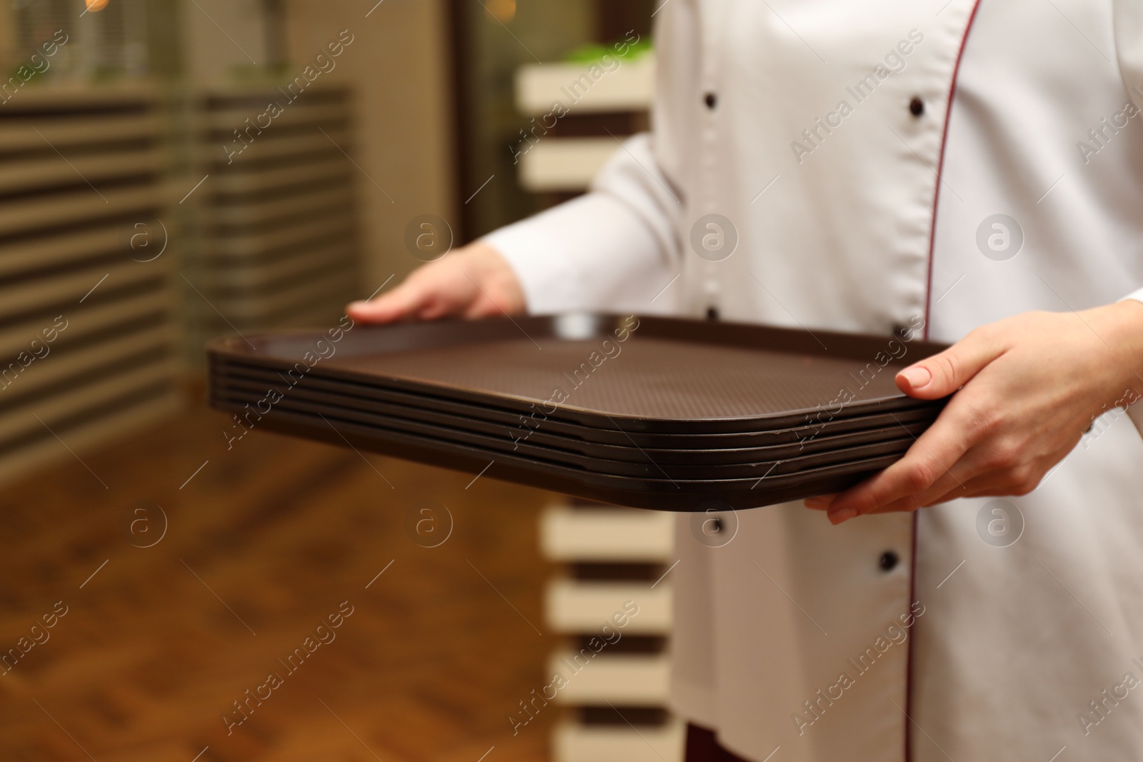 School canteen worker holding plastic trays for food indoors, closeup Photo of School canteen worker holding plastic trays for food indoors, closeup