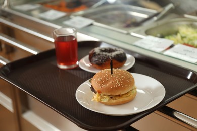Photo of Plastic tray with tasty food near serving line in school canteen
