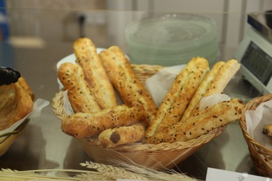 Photo of Wicker basket with bread sticks in school canteen. Tasty food