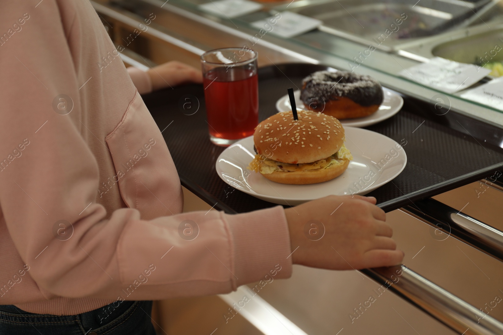 Little girl with plastic tray near serving line in canteen, closeup. School food Photo of Little girl with plastic tray near serving line in canteen, closeup. School food
