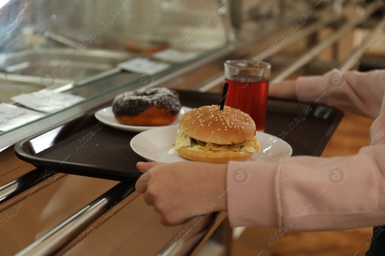 Little girl with plastic tray near serving line in canteen, closeup. School food Photo of Little girl with plastic tray near serving line in canteen, closeup. School food