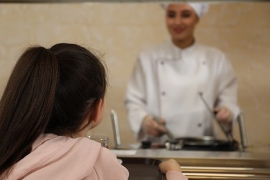 Photo of Little girl with plastic tray near serving line in canteen. School food