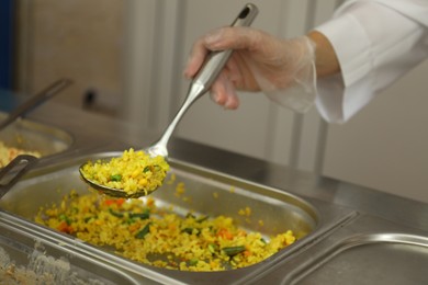 Photo of School canteen worker at serving line, closeup. Tasty food